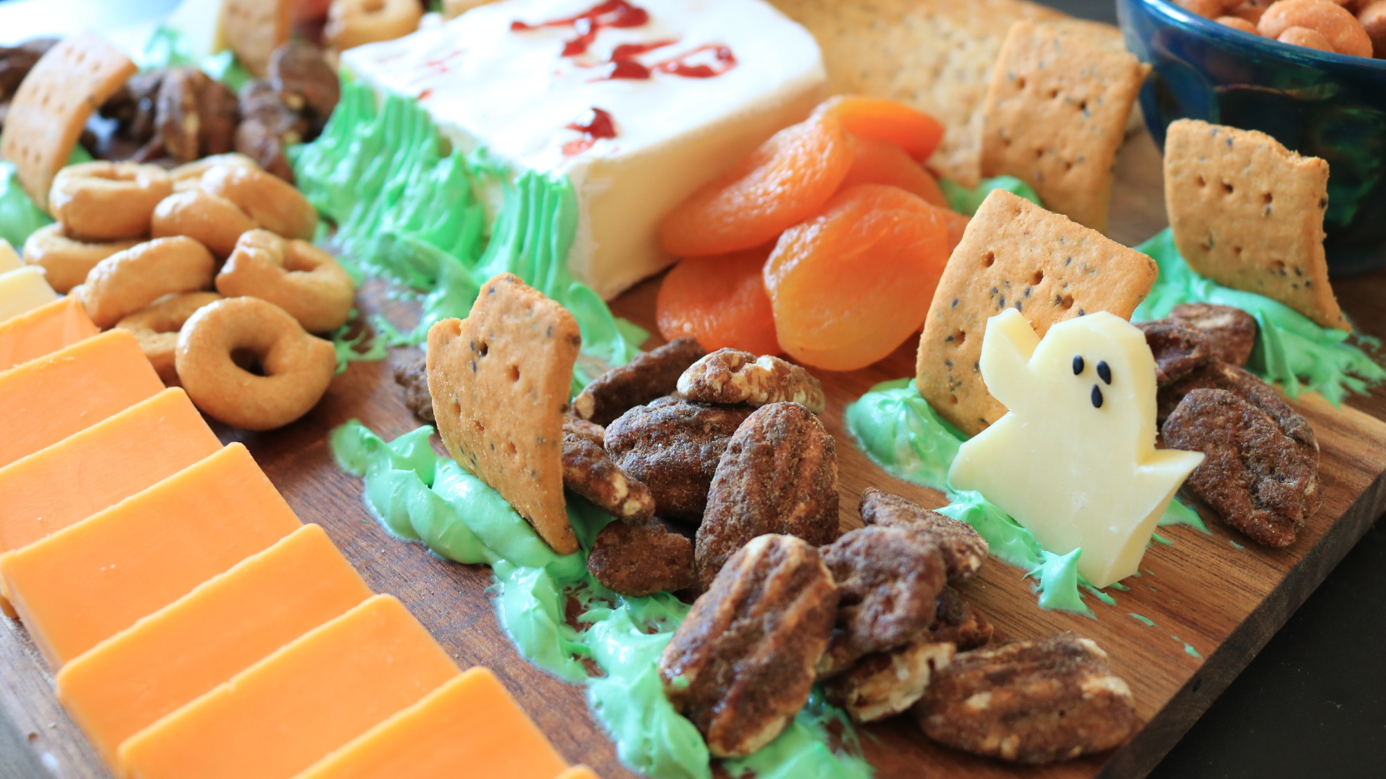 A charcuterie board with cheese carved to look like ghosts.